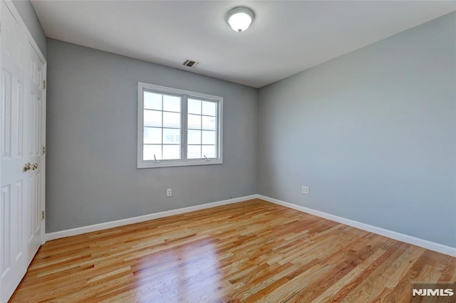 empty room featuring baseboards and light wood finished floors