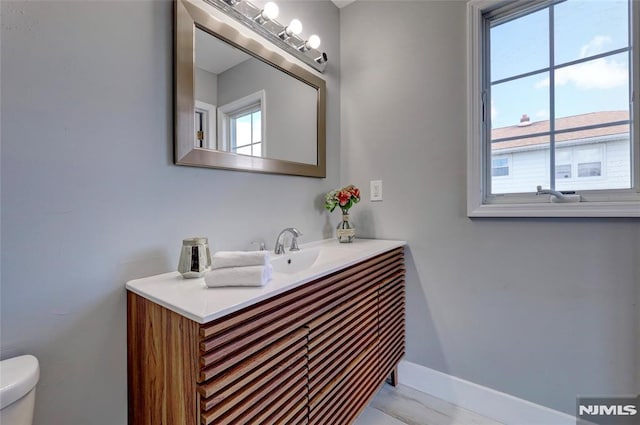 bathroom with vanity, toilet, and baseboards