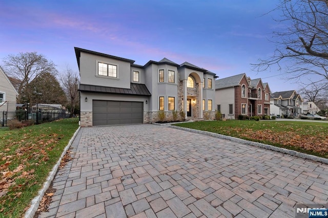 view of front of home featuring decorative driveway, stucco siding, a standing seam roof, a garage, and stone siding