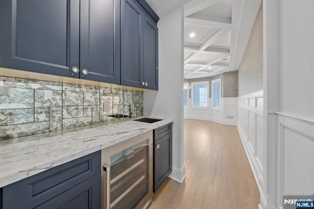 bar with light wood finished floors, tasteful backsplash, beverage cooler, coffered ceiling, and beamed ceiling