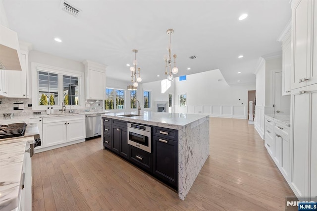 kitchen featuring appliances with stainless steel finishes, white cabinets, a sink, and dark cabinets