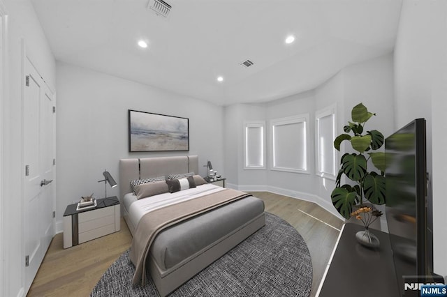 bedroom featuring light wood finished floors, visible vents, and recessed lighting