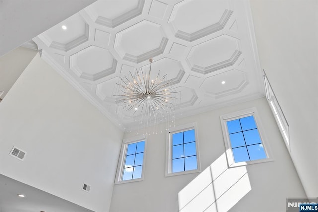 room details featuring a chandelier, coffered ceiling, visible vents, and crown molding