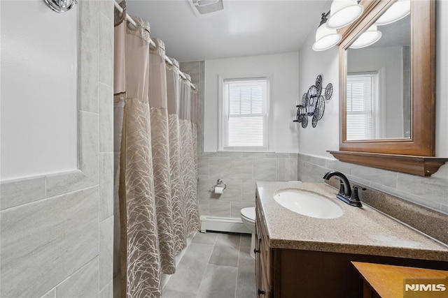 full bath with tile walls, visible vents, baseboard heating, toilet, and vanity