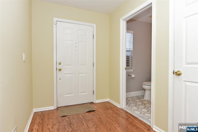 doorway with wood finished floors and baseboards