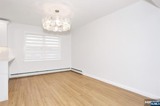 unfurnished dining area with light wood-style flooring, baseboards, baseboard heating, and a notable chandelier