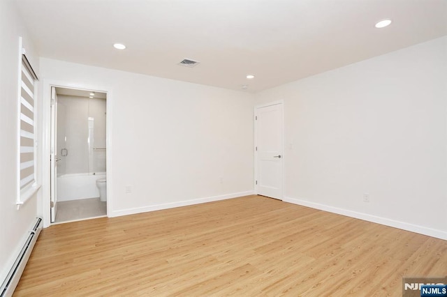 spare room with light wood-style floors, baseboards, baseboard heating, and recessed lighting