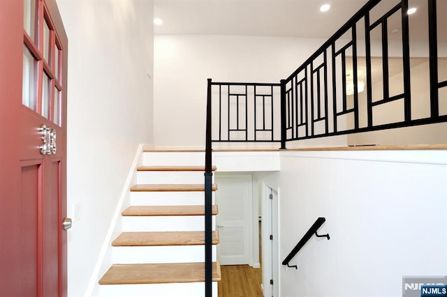 staircase featuring wood finished floors and recessed lighting