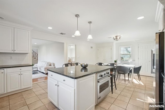 kitchen with appliances with stainless steel finishes, tasteful backsplash, visible vents, and light tile patterned floors