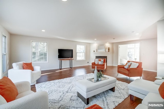 living area featuring a fireplace, dark wood finished floors, and recessed lighting