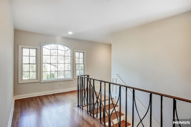 hall featuring recessed lighting, baseboards, an upstairs landing, and wood finished floors