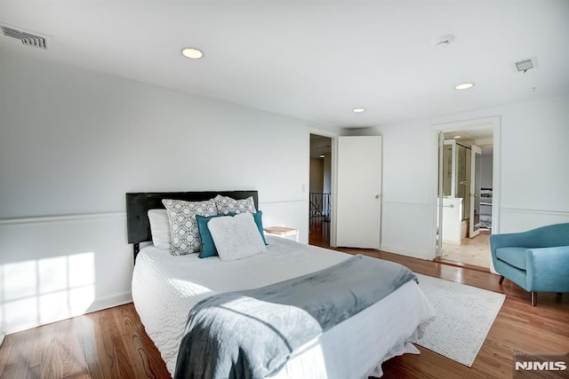 bedroom with baseboards, visible vents, wood finished floors, and recessed lighting