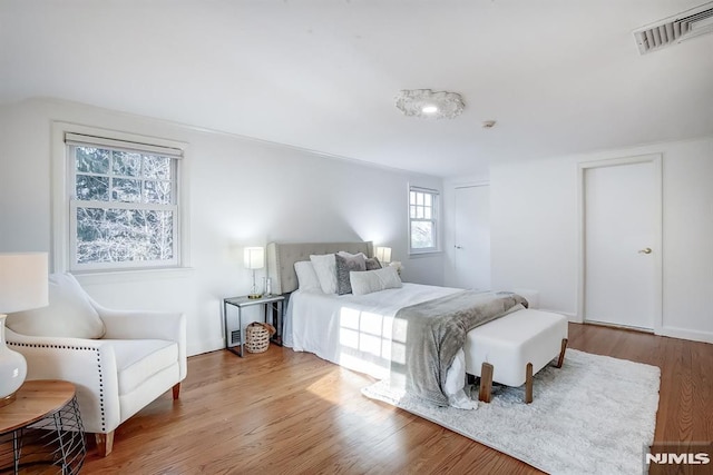 bedroom featuring visible vents and wood finished floors