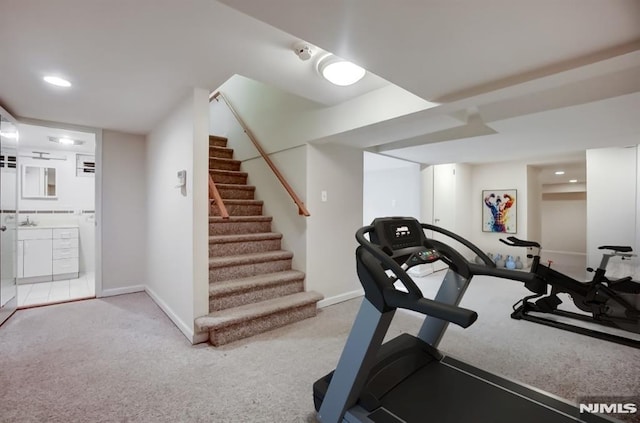 workout area featuring light carpet and baseboards