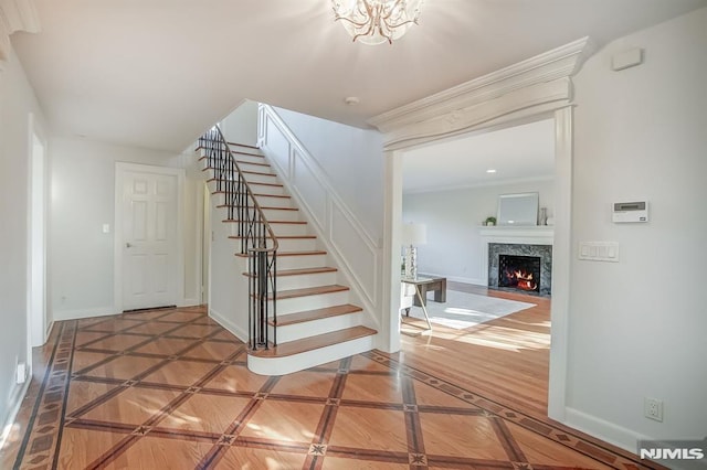 stairs featuring parquet floors, a fireplace, and baseboards