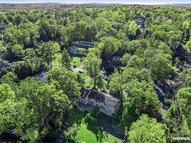 drone / aerial view with a wooded view