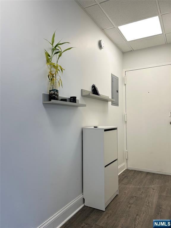 clothes washing area with dark wood-style floors, electric panel, and baseboards