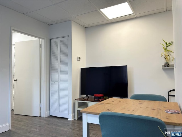 office space with a paneled ceiling, baseboards, and wood finished floors