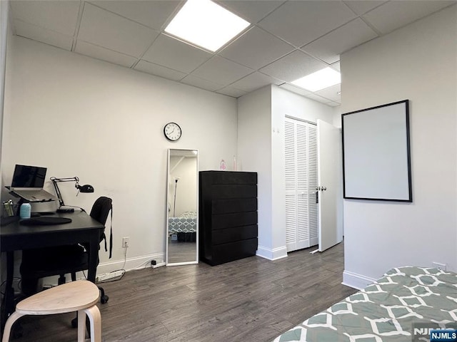 office area with a drop ceiling, baseboards, and wood finished floors