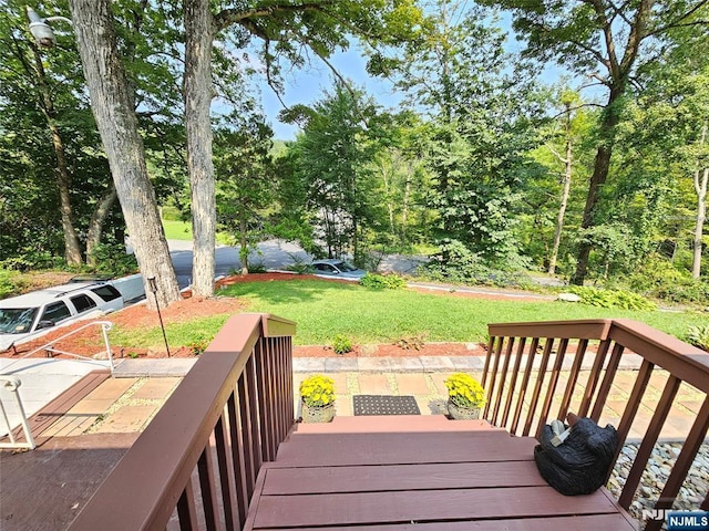 wooden terrace featuring a lawn