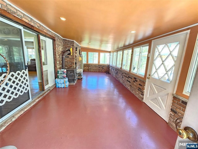 unfurnished sunroom with a wood stove