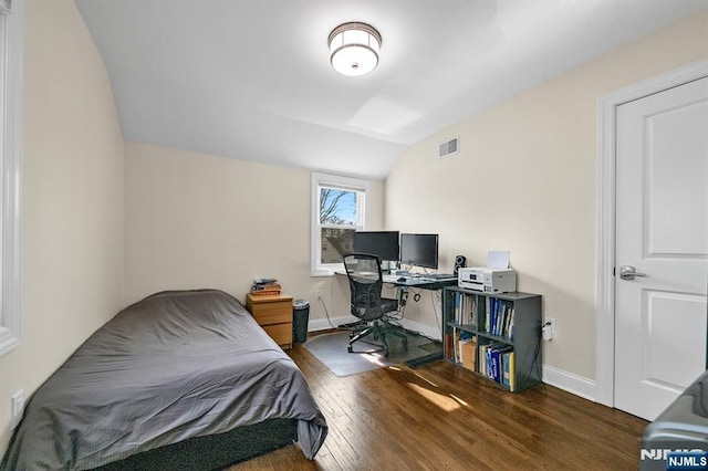 bedroom featuring visible vents, vaulted ceiling, baseboards, and wood finished floors