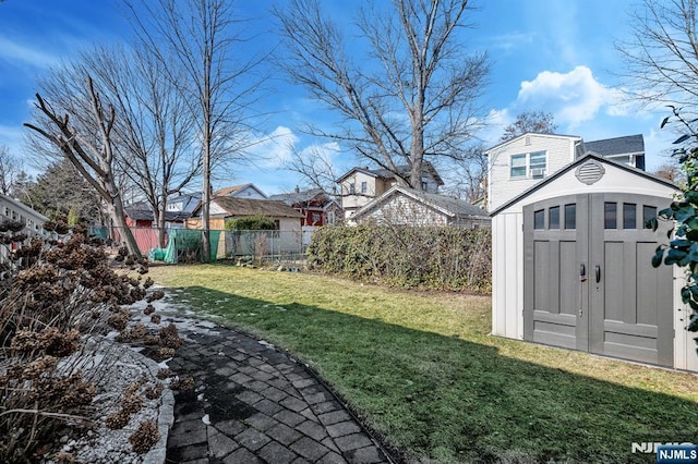 view of yard with a storage shed, fence, and an outdoor structure