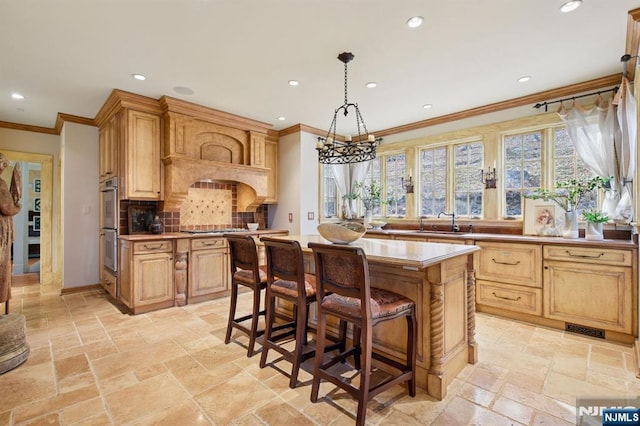 kitchen featuring backsplash, recessed lighting, a sink, and stone tile floors