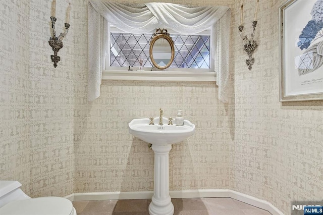 bathroom featuring toilet, wallpapered walls, tile patterned flooring, and baseboards