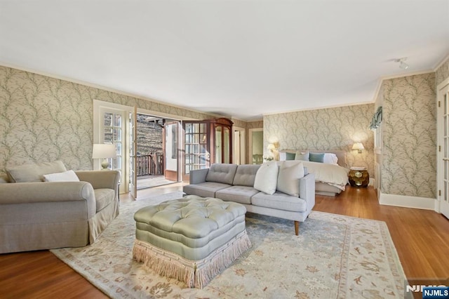 living area featuring ornamental molding, wood finished floors, and wallpapered walls