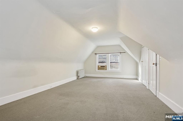 bonus room with lofted ceiling, radiator heating unit, carpet, and baseboards