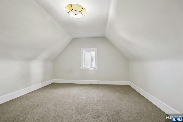 bonus room with lofted ceiling, carpet floors, and baseboards