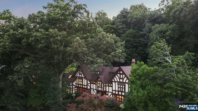 birds eye view of property featuring a view of trees