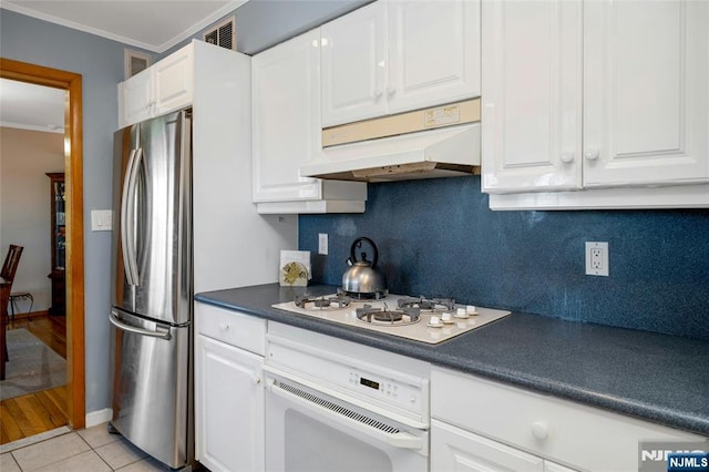 kitchen with ornamental molding, white appliances, decorative backsplash, and under cabinet range hood