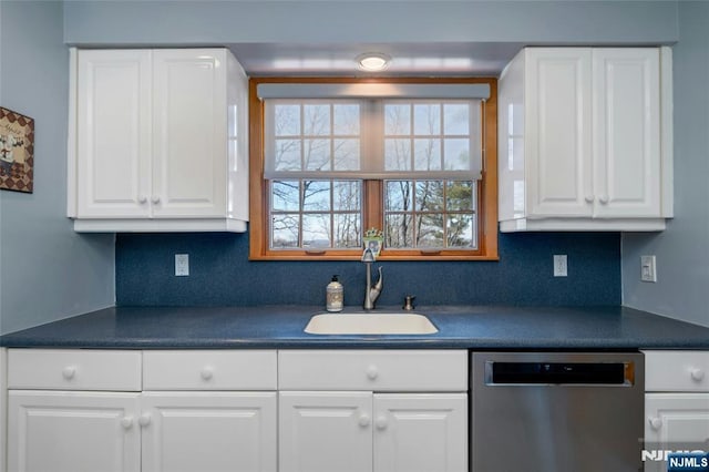 kitchen featuring a sink, dark countertops, white cabinetry, and stainless steel dishwasher