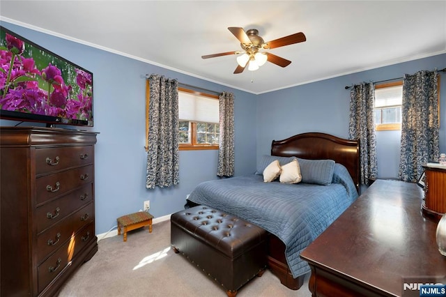 bedroom with light carpet, ceiling fan, baseboards, and crown molding