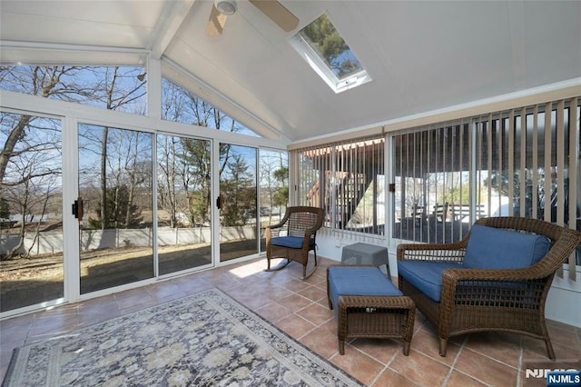 sunroom / solarium with vaulted ceiling with skylight, a wealth of natural light, and a ceiling fan