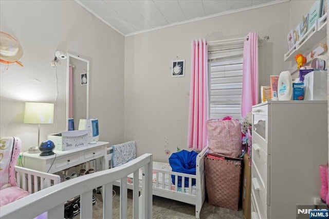 bedroom with a nursery area and ornamental molding