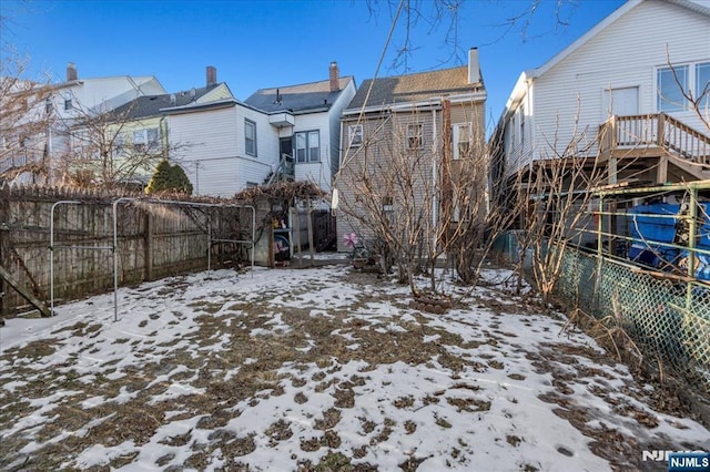 snow covered property with fence