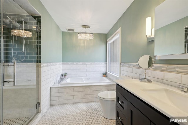 bathroom with an inviting chandelier, a stall shower, tile patterned flooring, tile walls, and a bath