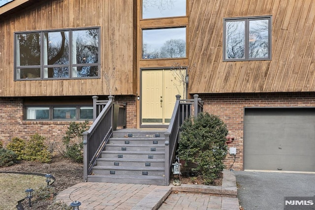 property entrance featuring brick siding and an attached garage