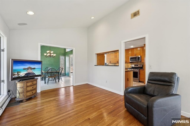 sitting room with a chandelier, visible vents, light wood-type flooring, and baseboards