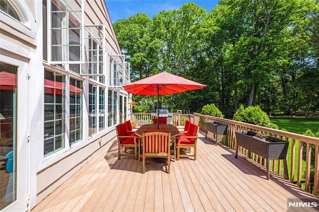 wooden deck featuring outdoor dining area and a grill