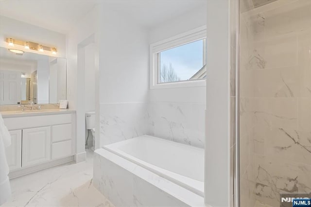 bathroom featuring a marble finish shower, toilet, marble finish floor, a garden tub, and vanity