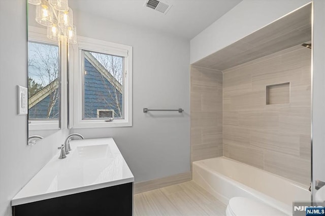 full bathroom with bathing tub / shower combination, visible vents, toilet, vanity, and baseboards