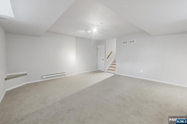 spare room with baseboards, visible vents, stairway, carpet floors, and a baseboard heating unit