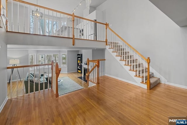 interior space featuring a chandelier, a high ceiling, wood finished floors, and baseboards