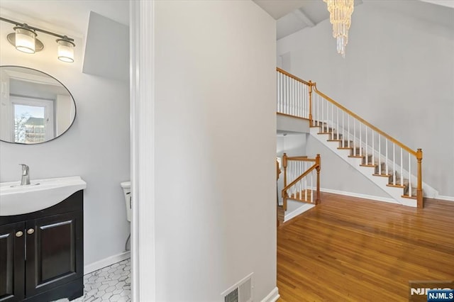 bathroom with toilet, visible vents, baseboards, and wood finished floors