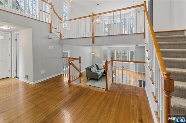 living area featuring visible vents, a high ceiling, and wood finished floors