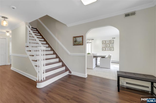 staircase with arched walkways, visible vents, crown molding, and wood finished floors